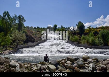 Srinagar, Inde. 24 août 2020. Un homme se repose près de la cascade pendant une journée chaude et ensoleillée à la périphérie de Srinagar. Crédit : SOPA Images Limited/Alamy Live News Banque D'Images