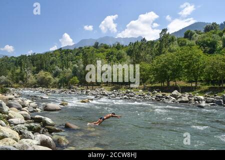 Srinagar, Inde. 24 août 2020. Un garçon cachemiri plonge dans la rivière pour se rafraîchir lors d'une chaude journée d'été à la périphérie de Srinagar. Crédit : SOPA Images Limited/Alamy Live News Banque D'Images