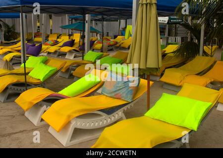 Chaises de plage aux couleurs vives dans un bar à Secret Beach, San Pedro, Ambergris Caye, Belize Banque D'Images