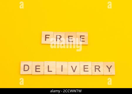 LIVRAISON SANS mot faite de cubes en bois sur fond jaune Banque D'Images