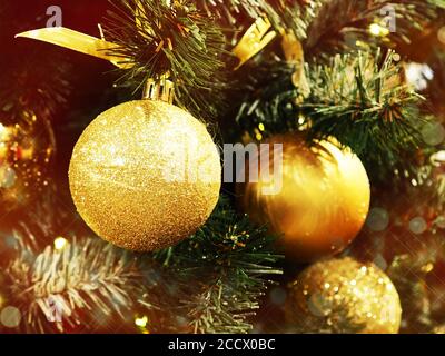 Gros plan d'une boule suspendue sur un arbre de Noël illuminé. Boules de Noël et de bibelots comme un fond pour des cartes postales, beaucoup de différents jouets de Noël dans Banque D'Images