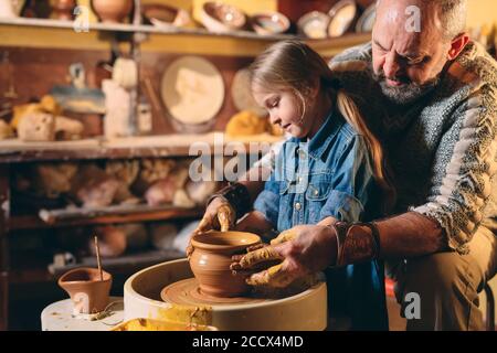 Atelier de poterie. Grand-père-fille enseigne la poterie. Modelage Banque D'Images