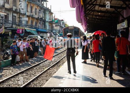 Conducteur avec drapeaux sur la plate-forme de la gare locale Dans le quartier Thon Buri de Bangkok Banque D'Images