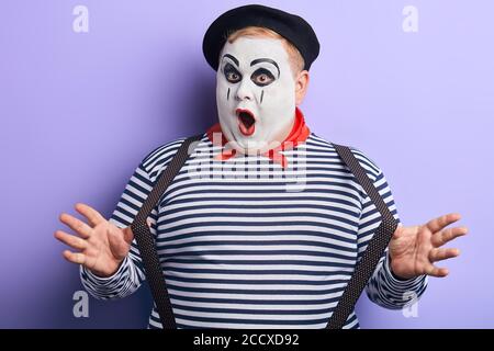 fou talentueux mime performance pantomime isolé sur fond bleu, doute concept. divertissement Banque D'Images