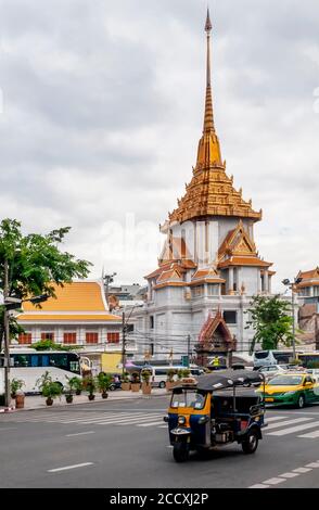 Tuk tuk et trafic de taxis dans les rues du centre de Bangkok, en Thaïlande, avec Wat Traimit, le Bouddha d'or en arrière-plan Banque D'Images