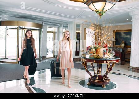 Jeunes filles près de la réception de l'hôtel. Les jeunes filles viennent à l'hôtel. Banque D'Images