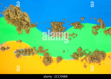 Encres vertes, jaunes et bleues mélangées à de la poudre dorée. Banque D'Images