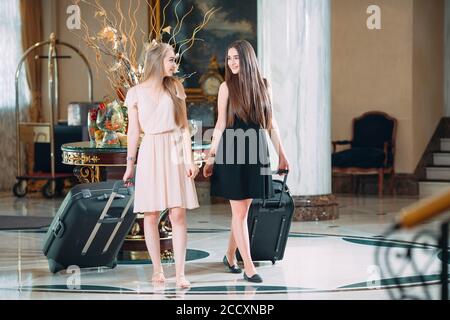 Jeunes filles près de la réception de l'hôtel. Les jeunes filles viennent à l'hôtel. Banque D'Images