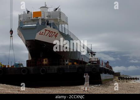 Portsmouth, Hampshire, Royaume-Uni. 24 août 2020. Les spectateurs voient le LCT 7074, le dernier char amphibie d'atterrissage encore en vie, avant de le déplacer au musée du jour J à Portsmouth, le lundi 24 août 2020. L'embarcation qui transportait à l'origine des chars et des soldats en Normandie, a été flottée par une barge du Musée national de la Marine royale, où elle a été restaurée, à la Promenade de Southsea, où une grue a construit un pont à la barge, Il pourrait donc être conduit jusqu'à sa nouvelle maison au musée du jour J. Crédit: Luke MacGregor/Alamy Live News Banque D'Images