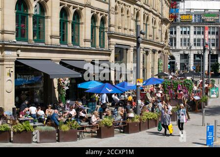 Manger dehors pour aider à la mise en place. La foule devant le restaurant Banyan dans le Corn Exchange, qui construit le programme le lundi. Manchester, Royaume-Uni. Banque D'Images