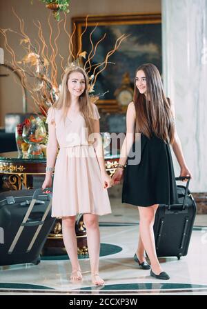 Jeunes filles près de la réception de l'hôtel. Les jeunes filles viennent à l'hôtel. Banque D'Images