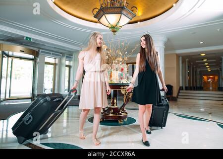 Jeunes filles près de la réception de l'hôtel. Les jeunes filles viennent à l'hôtel. Banque D'Images