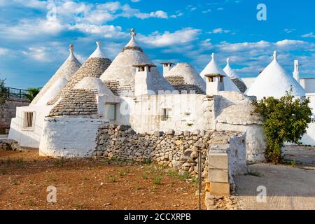 Groupe de belles Trulli, vieilles maisons traditionnelles et vieux mur en pierre à Puglia, Italie Banque D'Images