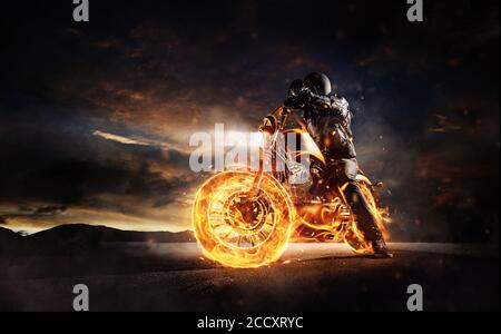 The motorbiker restant sur la gravure de moto dans le coucher du soleil la lumière. Art sombre wallpaper photo de moto. Très haute résolution Banque D'Images