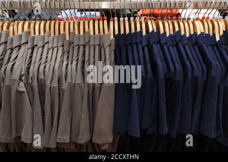 Polos pour hommes de différentes tailles sur cintres. Banque D'Images