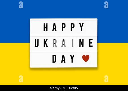 JOYEUX JOUR D'UKRAINE écrit dans une visionneuse sur un fond de couleur de drapeau d'Ukraine. Date du jour d'indépendance. Vue de dessus Banque D'Images