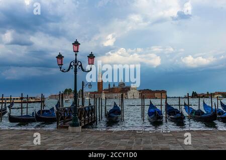 Parking gondoles à la fin de la Piazzetta San Marco, derrière eux la basilique San Giorgio Maggiore, Venise, Vénétie, Italie Banque D'Images