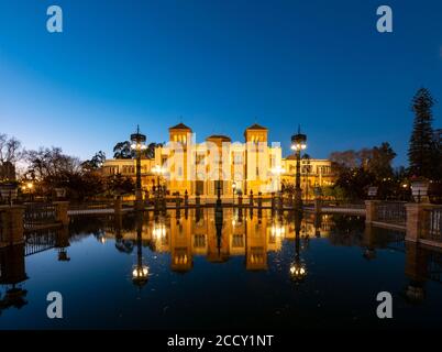 Musée d'art éclairé Museo de Artes y Costumbres Populares de Sevilla se reflète dans une fontaine, heure bleue, Plaza de America, Séville, Andalousie Banque D'Images