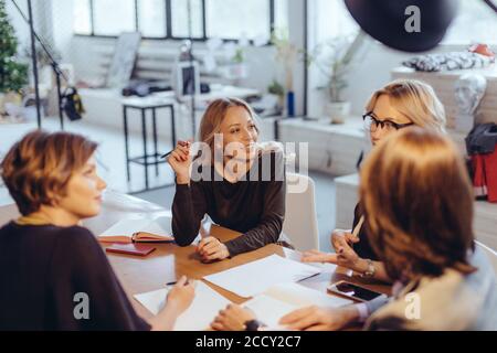 Les heures supplémentaires de travail concept. Groupe de jeunes de l'équipe d'affaires travailler tard le soir dans la salle de réunion d'essayer de remplir leurs missions. Prises dans le moderne Banque D'Images