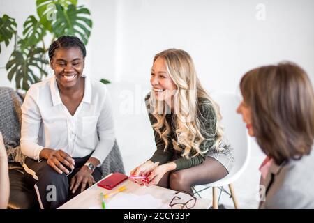 Concept de réflexion. Groupe d'mixed race female entrepreneurs se rencontrent pour discuter des plans pour l'avenir, faire l'analyse, tirer sur papier de diagramme Banque D'Images