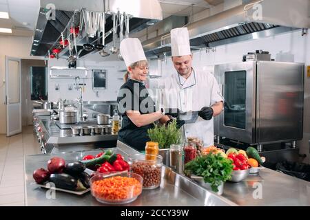 Deux chefs discutent du menu dans la cuisine d'un restaurant ou d'un hôtel. Banque D'Images