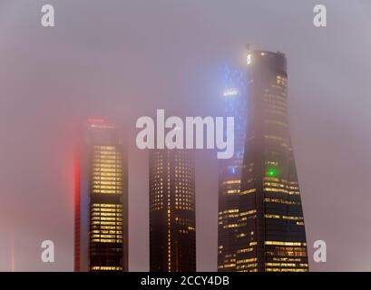 Bâtiment du quartier des affaires de Cuatro Torres illuminé par le brouillard du soir, Madrid, Espagne Banque D'Images