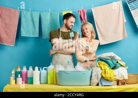 un jeune homme et une femme heureux donnant cinq hauts et souriant. portrait de près.arrière-plan bleu isolé. studio shot.bon travail. famille célébrant le succès Banque D'Images