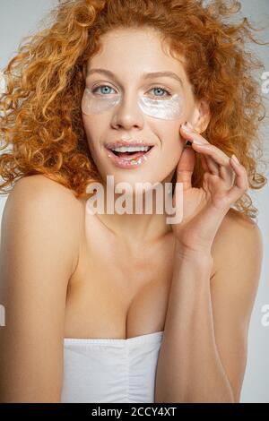 Magnifique femme aux cheveux bouclés portant des taches sous les yeux Banque D'Images