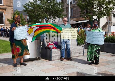 Les partisans de la vie au Zimbabwe comptent protester contre Helensburgh, en Écosse, avec des pancartes et un drapeau. Banque D'Images