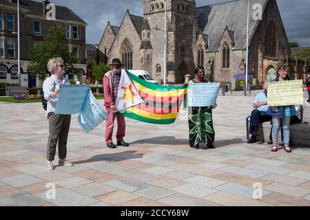 Les partisans de la vie au Zimbabwe comptent protester contre Helensburgh, en Écosse, avec des pancartes et un drapeau. Banque D'Images