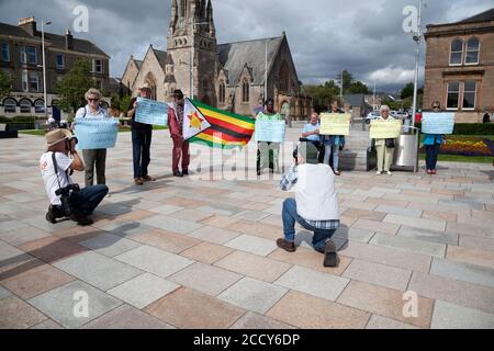 Les partisans de la vie au Zimbabwe comptent protester contre Helensburgh, en Écosse, avec des pancartes et un drapeau, avec des photographes de presse. Banque D'Images