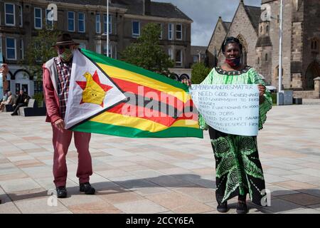 Les partisans de la vie au Zimbabwe comptent protester contre Helensburgh, en Écosse, avec des pancartes et un drapeau. Banque D'Images