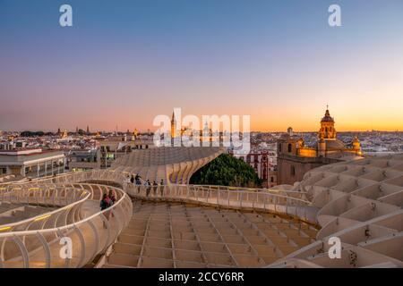 Vue sur Séville depuis le parasol Metropol au coucher du soleil, construction en bois courbée, cathédrale de Séville avec tour la Giralda, Iglesia del Salvador et Banque D'Images