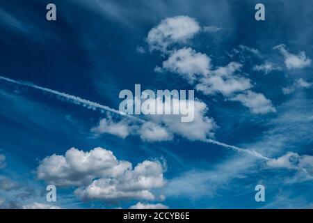 Nuages blancs et brume sur le ciel bleu. Sentier de condensation d'un avion volant à haute altitude. Trace de vapeur d'eau et de cristaux de glace. Élevée Banque D'Images
