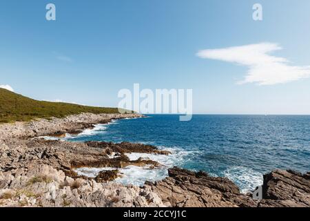 Bord de mer des Rocheuses près du camping Veslo au Monténégro. Bleu azur, vagues blanches qui frappent les rochers, jour d'été ensoleillé, vue aérienne sur les drones. Banque D'Images