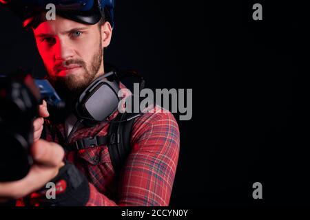 Gros plan de beardy man avec VR Gun, visant l'appareil photo, homme regarder l'appareil photo. Isolé sur fond noir Banque D'Images