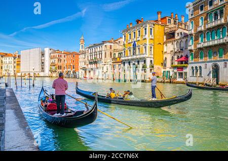 Venise, Italie, 13 septembre 2019 : gondolier et touristes en gondole bateau traditionnel naviguant sur l'eau du Grand Canal avec architecture vénitienne typique bâtiments colorés arrière-plan Banque D'Images