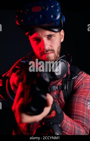 Gros plan de beardy man avec VR Gun, visant l'appareil photo, homme regarder l'appareil photo. Isolé sur fond noir Banque D'Images