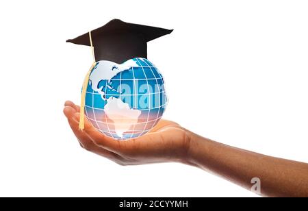 Main tenant le globe dans le capuchon de graduation sur blanc Banque D'Images