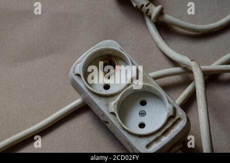 État de la prise électrique, prise après choc sur fond marron. Barre d'alimentation blanche après court-circuit. Sécurité électrique. Banque D'Images