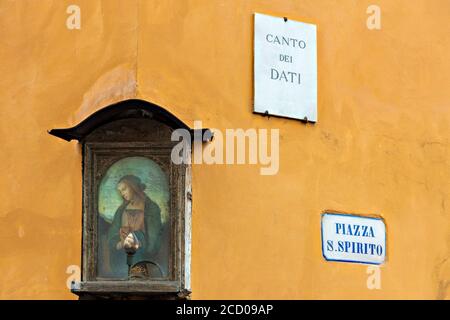 Un aperçu poétique sur la piazza Santo Spirito coeur de la Quartier populaire de San Frediano à Florence avec un petit tabernacle au premier plan Banque D'Images