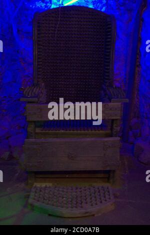 Le méprisé chaise en fer utilisé pour la torture inhumaine avec un étrange lumière bleue derrière Banque D'Images