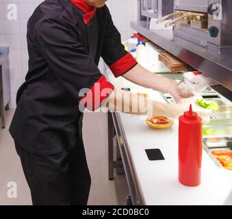 Faire cuire en ajoutant la laitue sur le hamburger. Préparation du hamburger au restaurant. Banque D'Images