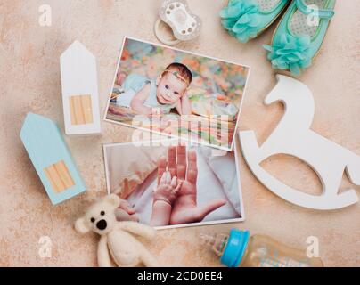 Images, accessoires et jouets de bébé fille sur fond beige. Vue de dessus, plan d'appartement. Banque D'Images