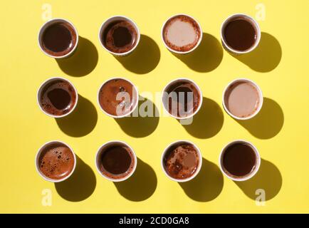 Tasses à café avec différents types de café, cappuccino et macchiato sur fond jaune. Vue de dessus, plan d'appartement Banque D'Images