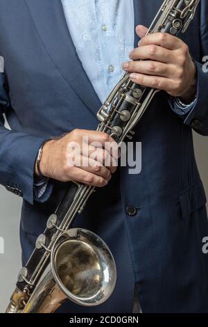 Gros plan des mains de sexe masculin tenant une clarinette basse, photo rognée. Photo de haute qualité Banque D'Images