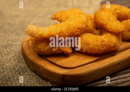 Crevettes de l'Atlantique frites dans de la pâte sur un plateau de service en bois. Gros plan Banque D'Images