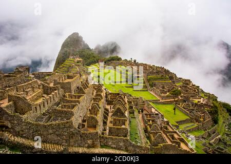 La ville sacrée du Machu Picchu a pris le soleil et s'est enveloppée dans des nuages bas; Cusco, Pérou Banque D'Images