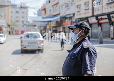 Gaza, Palestine. 25 août 2020. Un policier se tient sur la garde tout en portant un masque facial comme mesure préventive pendant le confinement du coronavirus (COVID-19). Gaza a signalé ses premiers cas dans la population générale alors que les autorités ont confirmé quatre infections dans un camp de réfugiés et que les forces de sécurité ont déclaré un confinement complet pendant 48 heures. Les quatre cas provenaient d'une seule famille, selon une déclaration du gouvernement. La fermeture touchera toute la bande de Gaza, selon un responsable du Hamas, le groupe qui gouverne le territoire. Crédit : SOPA Images Limited/Alamy Live News Banque D'Images