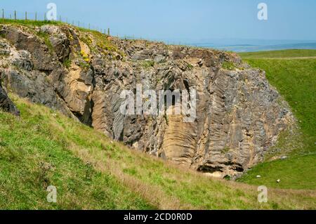 Vue à distance d'un système naturel de cavernes tronquées par l'exploitation en carrière au Dirtlow Pit, Dirtlow Rake près de Castleton, Derbyshire Banque D'Images